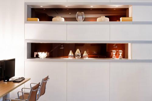 a kitchen with white cabinets and a table and chairs at AC Hotel Algeciras by Marriott in Algeciras