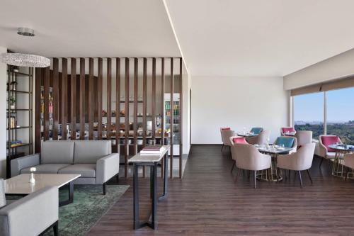 a dining room with tables and chairs at Courtyard by Marriott Bhopal in Bhopal