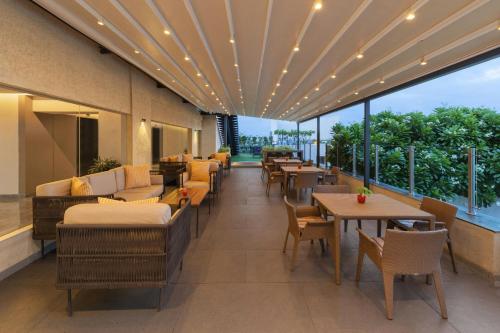 a restaurant with couches and tables and windows at Courtyard by Marriott Bhopal in Bhopal