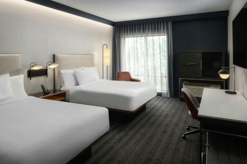 a hotel room with two beds and a desk at Courtyard by Marriott Gainesville GA in Gainesville