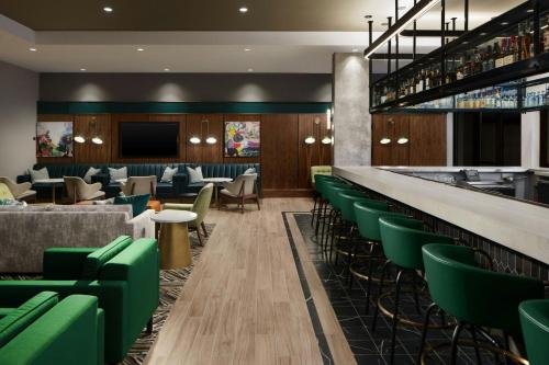 a lobby with green chairs and a bar at Courtyard by Marriott Gainesville GA in Gainesville