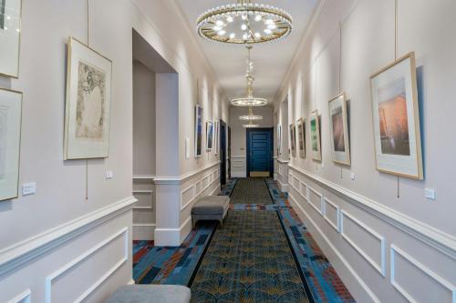 a hallway with paintings on the walls and a chandelier at Courtyard by Marriott Gainesville GA in Gainesville