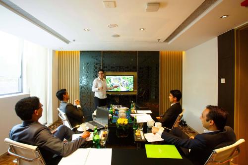 a group of people sitting around a table in a meeting room at Courtyard by Marriott Agra in Agra