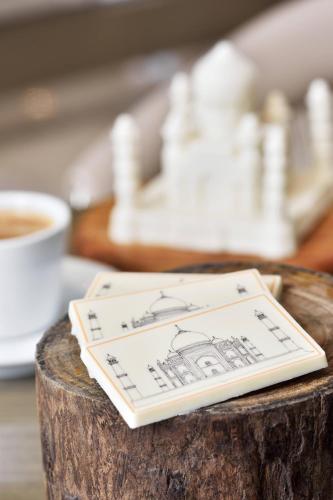 a black and white card on a wooden stump with a cup of coffee at Courtyard by Marriott Agra in Agra
