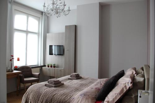 sypialnia z łóżkiem, krzesłem i żyrandolem w obiekcie B&B @ Room's w mieście Ypres