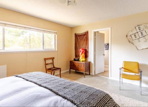 a bedroom with a bed and a chair and a window at Mid-Century Hideaway - privat Pool & King Bed in Yucca Valley