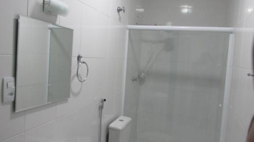 a white bathroom with a shower and a toilet at Colonial Hotel Itatiba in Itatiba