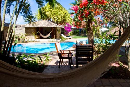 a hammock in a resort with a swimming pool at Pousada Berro do Jeguy in Pipa