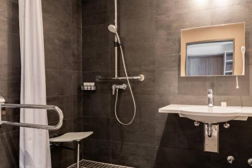a bathroom with a shower and a sink at AC Hotel by Marriott Berlin Humboldthain Park in Berlin