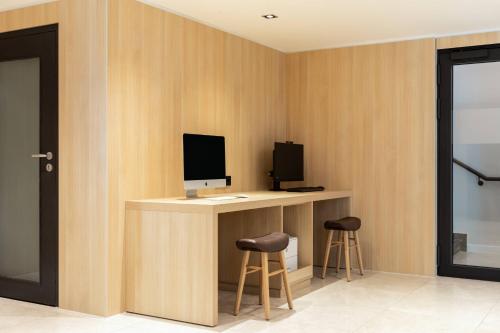 a room with a desk with a computer and two stools at AC Hotel by Marriott Berlin Humboldthain Park in Berlin