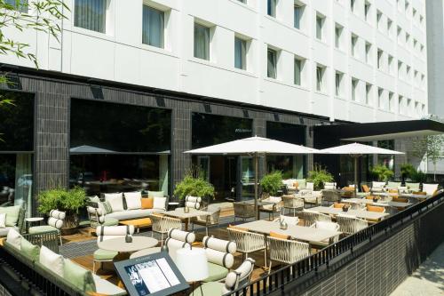 a restaurant with tables and umbrellas in front of a building at AC Hotel by Marriott Berlin Humboldthain Park in Berlin