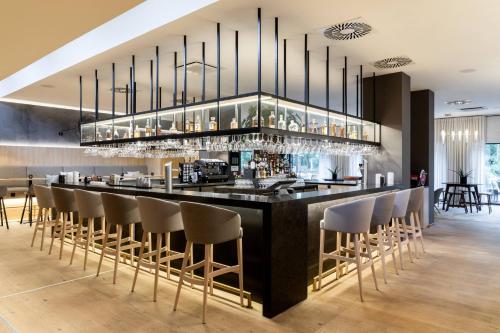 a bar in a restaurant with a bunch of stools at AC Hotel by Marriott Berlin Humboldthain Park in Berlin