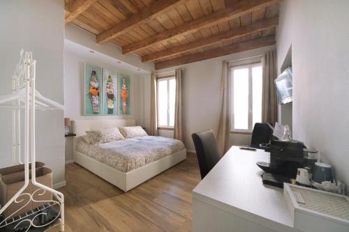 a bedroom with a bed and a desk and a table at Al Vecchio CIVICO 1 in Stellanello