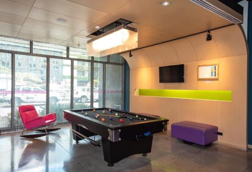 a billiard room with a pool table and two chairs at Aloft Bogotá Airport in Bogotá