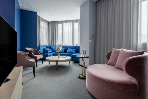 a living room with a couch and a tv at Hotel Luc, Autograph Collection in Berlin