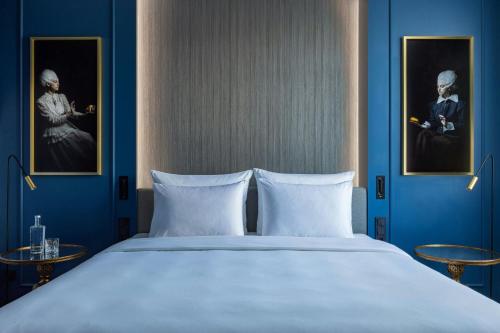 a bedroom with a large bed with blue walls at Hotel Luc, Autograph Collection in Berlin