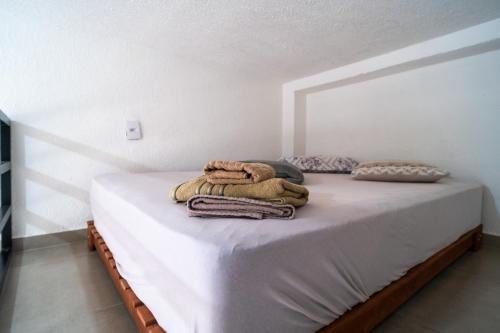 a bed with towels on it in a room at Pousada jardim do Sol in Sorocaba