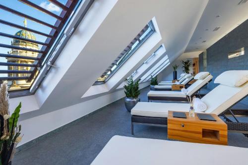 an attic room with two beds and a couch at Hotel Luc, Autograph Collection in Berlin