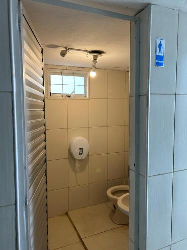 a bathroom with a toilet and a window at Chácara das Oliveiras in Campinas