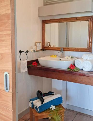 a bathroom with a sink and a mirror and towels at Moorea Island Beach Hotel in Moorea