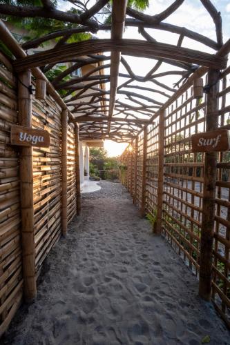 a wooden walkway with a wooden pergola at Tierra Munay in Las Tunas