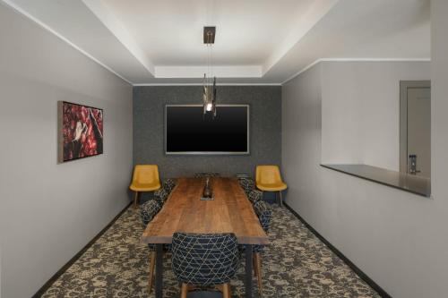 a conference room with a wooden table and yellow chairs at Epicurean Atlanta, Autograph Collection in Atlanta