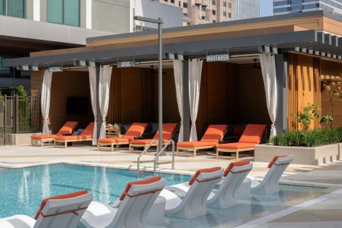 a swimming pool with orange chairs next to a building at Epicurean Atlanta, Autograph Collection in Atlanta