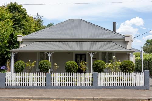 a small house with a white picket fence at Arendon Cottage in Evandale