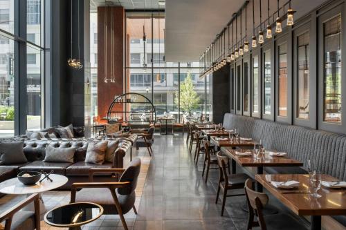 a restaurant with couches and tables and windows at Epicurean Atlanta, Autograph Collection in Atlanta