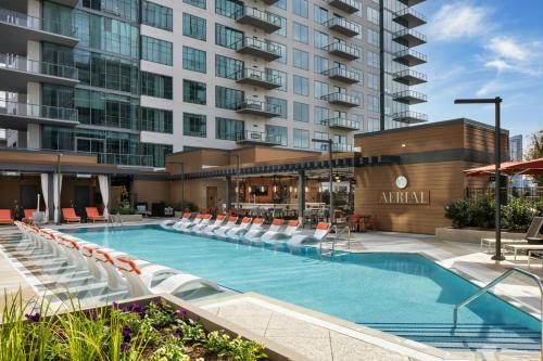 a swimming pool with lounge chairs and a building at Epicurean Atlanta, Autograph Collection in Atlanta