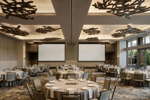 a banquet hall with tables and chairs and blank screens at Epicurean Atlanta, Autograph Collection in Atlanta