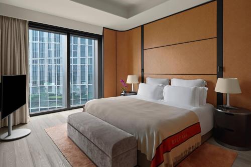 a bedroom with a large bed and a large window at Bvlgari Hotel Beijing in Beijing