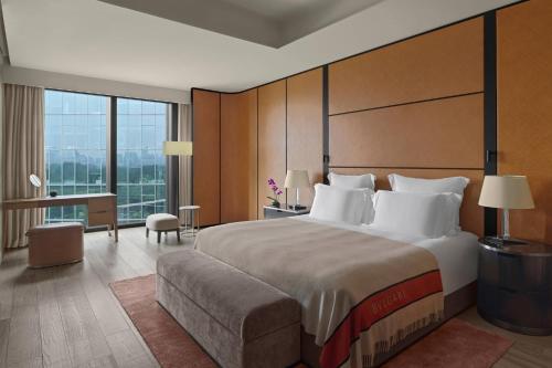 a bedroom with a large bed and a large window at Bvlgari Hotel Beijing in Beijing