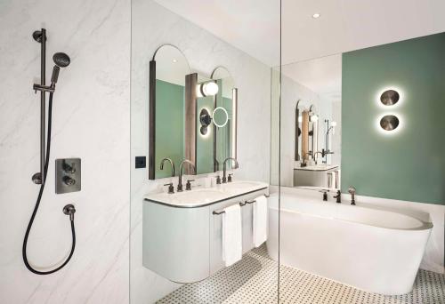 a bathroom with two sinks and a tub and a shower at Hotel Taschenbergpalais Kempinski in Dresden