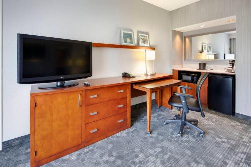 a hotel room with a desk with a tv and a desk sidx sidx sidx sidx at Courtyard Atlanta Norcross/Peachtree Corners in Norcross