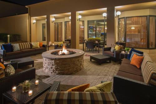 a living room with a fire pit with couches and tables at Courtyard Atlanta Norcross/Peachtree Corners in Norcross