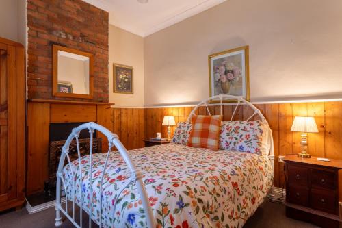 a bedroom with a bed with a wooden wall at Arendon Cottage in Evandale