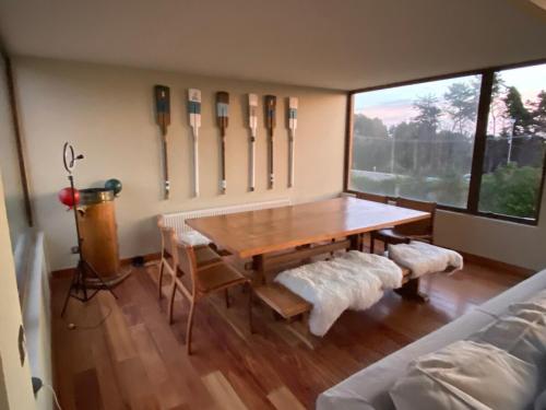 a dining room with a wooden table and a window at Condominio Fundo Zapallar in Cachagua