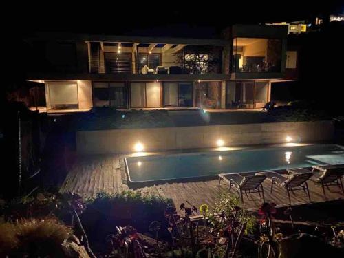 a house with a swimming pool at night at Condominio Fundo Zapallar in Cachagua
