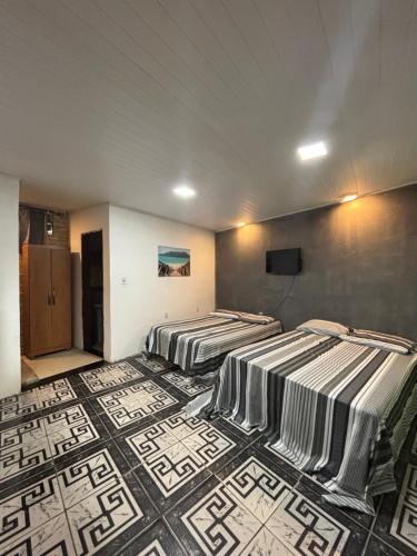 - 2 lits dans une chambre dotée de carrelage dans l'établissement Kitnet Maria Bonita - Cabo frio, à Cabo Frio