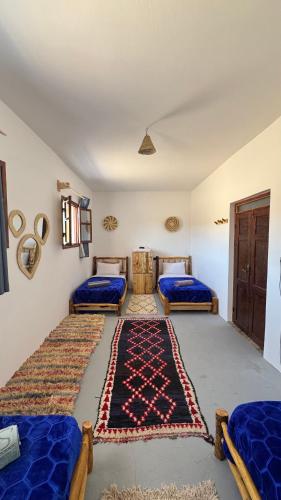 1 dormitorio con 2 camas y alfombra en el suelo en Quadruple room in fisherman house, en Wassane