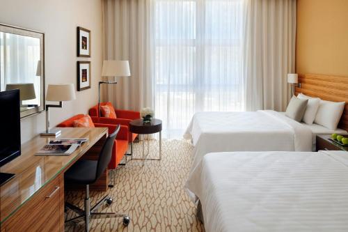a hotel room with two beds and a television at Courtyard by Marriott World Trade Center, Abu Dhabi in Abu Dhabi