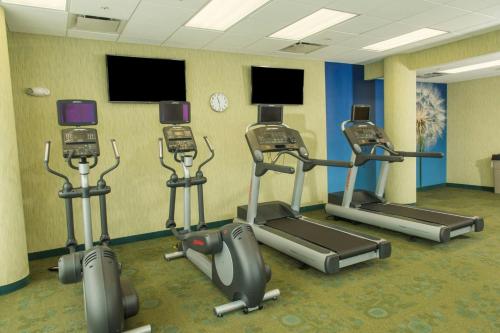 a gym with several cardio machines in a room at SpringHill Suites by Marriott Buffalo Airport in Williamsville