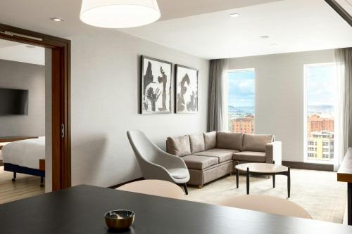 a living room with a couch and a bed at AC Hotel by Marriott Belfast in Belfast