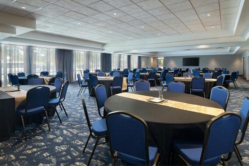 a conference room with tables and chairs and a screen at Courtyard by Marriott Austin Dripping Springs in Dripping Springs