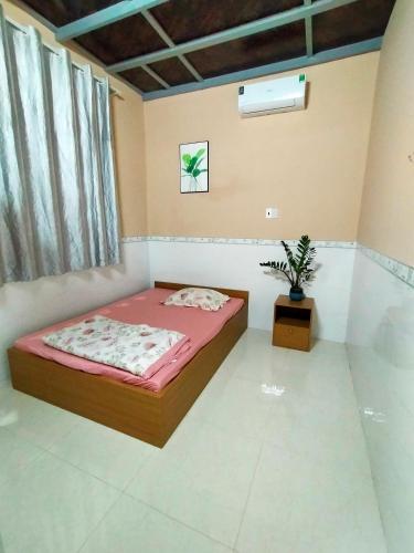 a bedroom with a bed and a potted plant in it at Homestay Vạn Hưng in Vạn Ninh