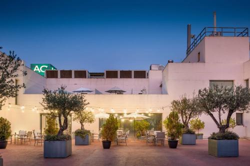 a building with a courtyard with tables and chairs at AC Hotel Badajoz by Marriott in Badajoz