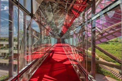 a glass corridor in a building with a red floor at Hotel Marqués de Riscal, a Luxury Collection Hotel, Elciego in Elciego