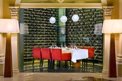 a dining room with a table and red chairs at The Ritz-Carlton Abu Dhabi, Grand Canal in Abu Dhabi