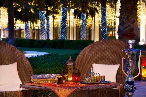 a table with two chairs and a table with candles at The Ritz-Carlton Abu Dhabi, Grand Canal in Abu Dhabi